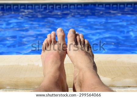 Male feet at swimming-pool