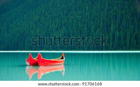 Canoes floating peacefully on the waters of Lake Louise, Banff National Park, Alberta, Canada.