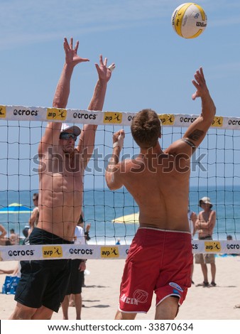 MANHATTAN BEACH, CA. - JULY 18: Mike Placek spikes the ball and Austin Rester attempts to block him at the AVP Manhattan Beach Open on July 18, 2009 in Manhattan Beach, CA.