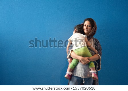 Image, Stock Photo Muslim mother embraced slept little girl in front of blue wall background