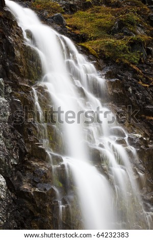 A stream of water falling down a rocky mountainside. Long exposure.