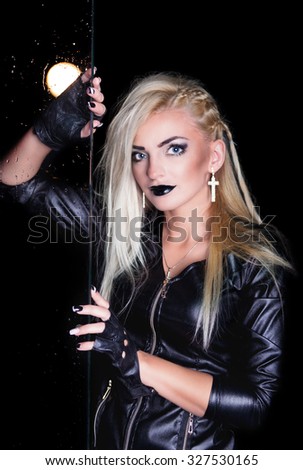 Girl model dressed in leather jacket in studio with water drops and flash