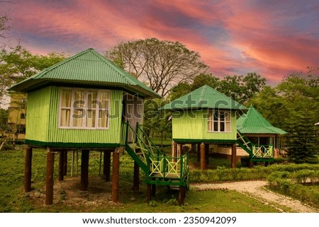 Image, Stock Photo A few wooden huts and many bushes and trees are standing around on a hilly green meadow landscape in the nature park Ammergau Alps in Upper Bavaria and a piece of bicycle path can be seen as well.