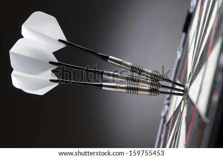 Three darts in bullseye of dartboard