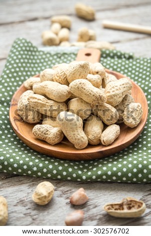 Many peanuts in shell on polkadot fabric on wooden