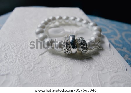 Wedding bracelet with pearls on a beautiful wedding invitation