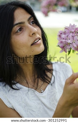 Young South Asian woman looking at flowers