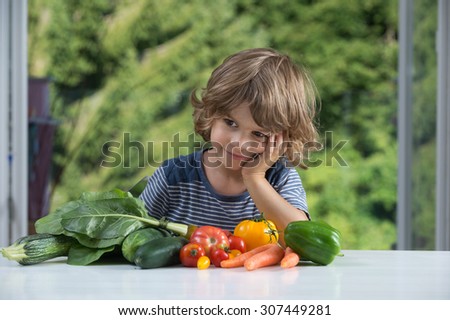 Cute little boy sitting at the table excited about vegetable meal, bad or good eating habits, nutrition and healthy eating concept