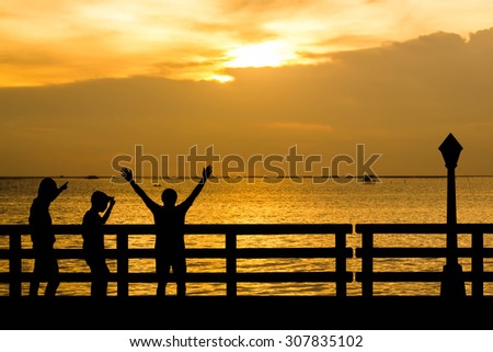 Silhouette successful  men or winner men on Over blur Beautiful evening sunset above the sea