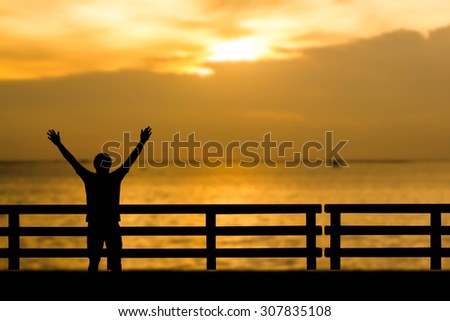 Silhouette successful  man or winner man on Over blur Beautiful evening sunset above the sea