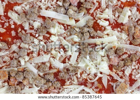 A close view of an individual frozen three meat pizza.