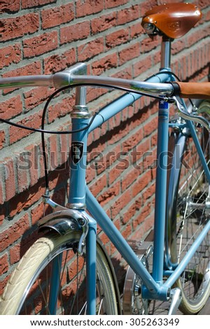Milano, Italy - June 30, 2013: A luxury vintage Italian fixed-gear (fixie) bike in sky blue with leather saddle and grips and cream white tubes.