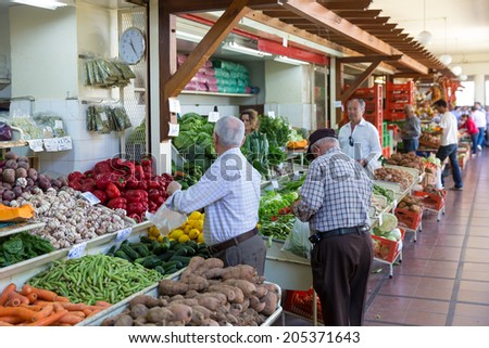 FUNCHAL, PORTUGAL - MAY 02: Unknown people visiting the vegetable market of the famous Mercado dos Lavradores on May 02, 2014 in Funchal, capital city of Madeira, Portugal
