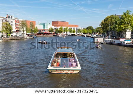 AMSTERDAM, THE NETHERLANDS - AUG 06: Canal with recreating people in a cruise ship on August 06, 2015 downtown in Amsterdam, capital city of The Netherlands