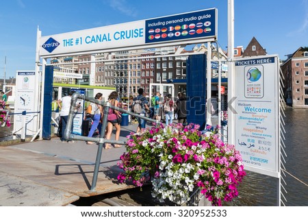 AMSTERDAM, THE NETHERLANDS - AUG 06: Tourists buying tickets at a departure place of Amsterdam canal cruises on August 06, 2015 in Amsterdam, the Netherlands