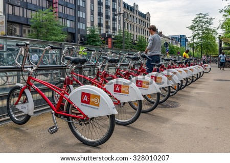 ANTWERP, BELGIUM - AUG 11: Man is parking a bicycle at an automatic bicycle rental for shared bicycles on August 11, 2015 in Antwerp, Belgium