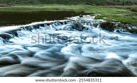 Similar – Foto Bild Schneller Fluss, der durch ein Bergtal fließt