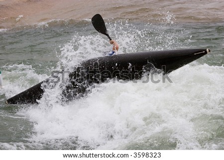 A canoeist trying to right his canoe or avoid tipping over
