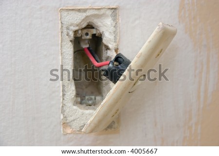 A light switch hanging off the wall