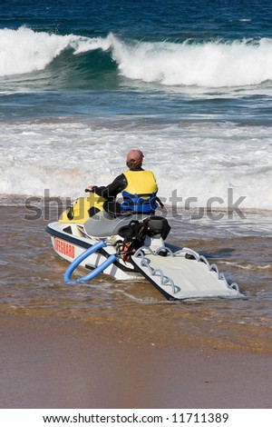 A life guard on the beach with his Jet Ski