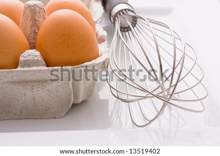 A half dozen carton of eggs with a whisk - the mortal enemy of the egg