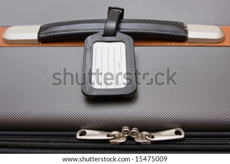 A black luggage tag on a handle on a bag