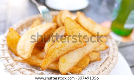 Potato fries on the bamboo dish with beer and fork