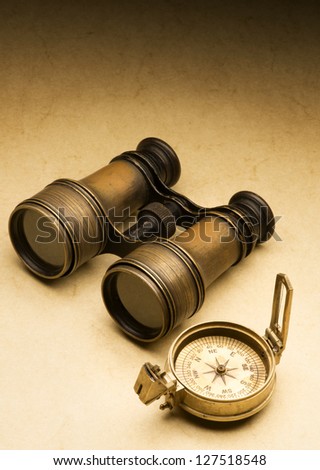 ancient binoculars  and compass on the ancient paper