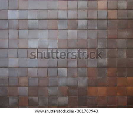 Brown shiny square tile cladding on exterior of a building of a department store built in the communist era of Czechoslovakia.