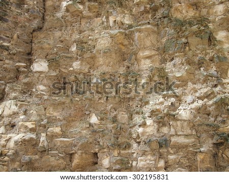 Wall of a an old bastion (Prague, 17th century). The wall crumbles and reveals the inner layer of stones.