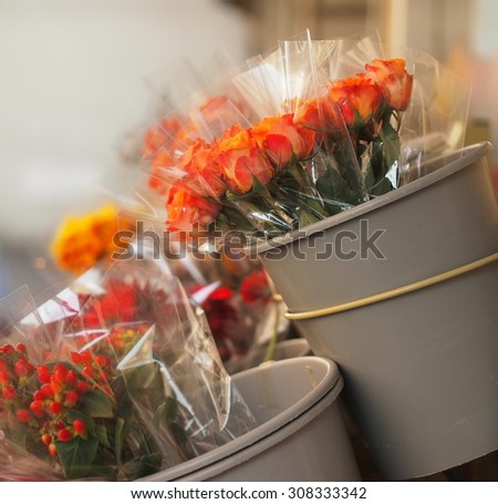 Close-up view of bouquets wrapped in cellophane in the flower shop - orange roses.
