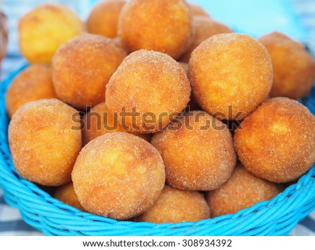 Arancini - Fried rice balls with saffron filled with prosciutto and cheese in a blue wicker basket - unusual specialty.