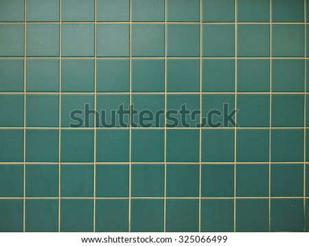 Green square tiles cladding background.