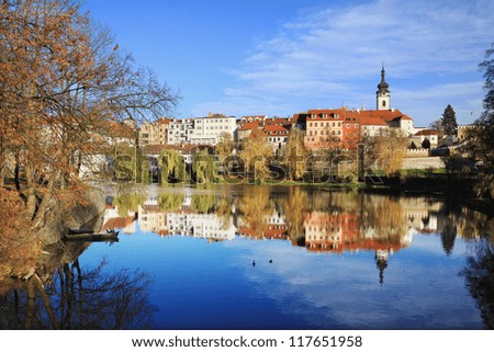 Colorful autumn medieval Town Pisek above the river Otava with the gothic deanery Church, Czech Republic