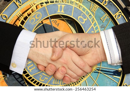 Businessmen shaking hands in front of the historical Clock