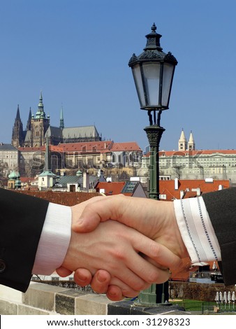 Businessmen shaking hands with Charles Bridge in Prague