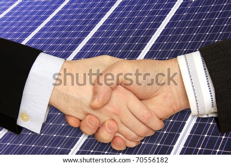 Businessmen shaking hands in front of Solar Power Station