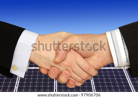 Businessmen shaking hands in front of the Solar Power Station