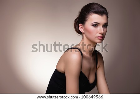Portrait of luxury woman in exclusive jewelry and  black dress on natural background