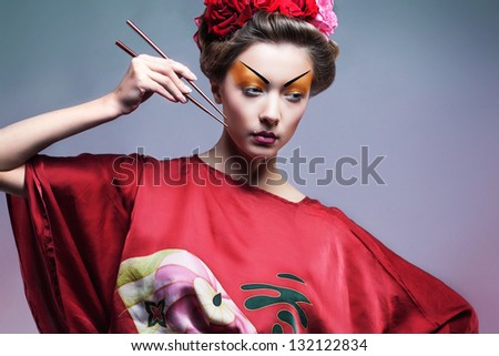 Fashion asian woman wearing traditional japanese red kimono  with umbrella, studio shot.  Geisha