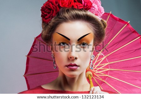 Fashion asian woman wearing traditional japanese red kimono  with umbrella, studio shot.  Geisha