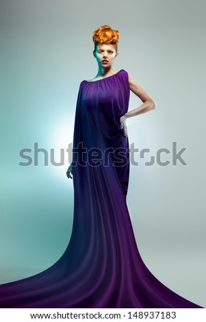 Fashion studio shot of beautiful  woman in violet dress with  Professional makeup and hairstyle