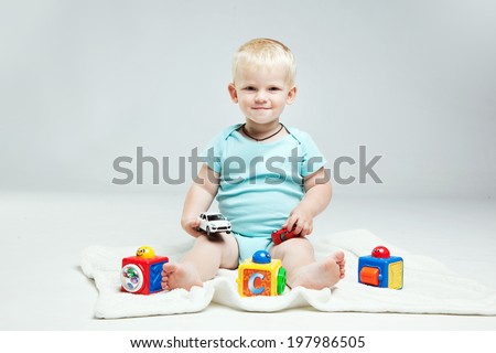 Smiling Baby boy is  playing with educational toys