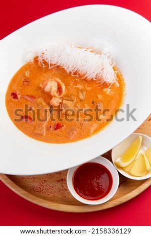 Traditional tom yum soup. On a red background. Selective focus. Imagine de stoc © 