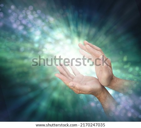 Channelling healing energy to where it is needed - male cupped hands with light between and a stream of outward spiralling green  energy against a bokeh background and copy space
 ストックフォト © 