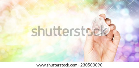 Crystal healing website banner - Crystal Healer holding large clear quartz puff heart crystal on sparkles and rainbow colored bokeh background