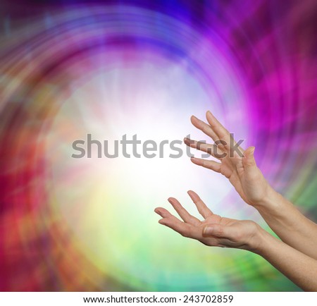 Sensing Vortex Energy Field - Pair of female hands reaching upwards into a vibrant energy vortex field with plenty of copy space