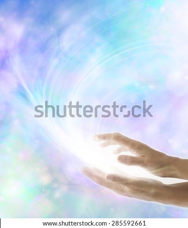 Spirit Release - Female parallel hands with a white energy formation between appearing to leave and move away  on an ethereal misty bokeh blue background with plenty of copy space