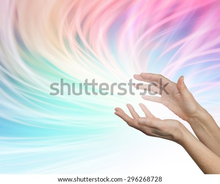 Sending distant healing energy - Female outstretched healing hands appearing to send energy out on a flowing rainbow colored  vivid whooshing energy formation background
