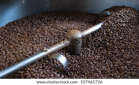 A batch of freshly roasted coffee beans cool down after emerging from a roaster.